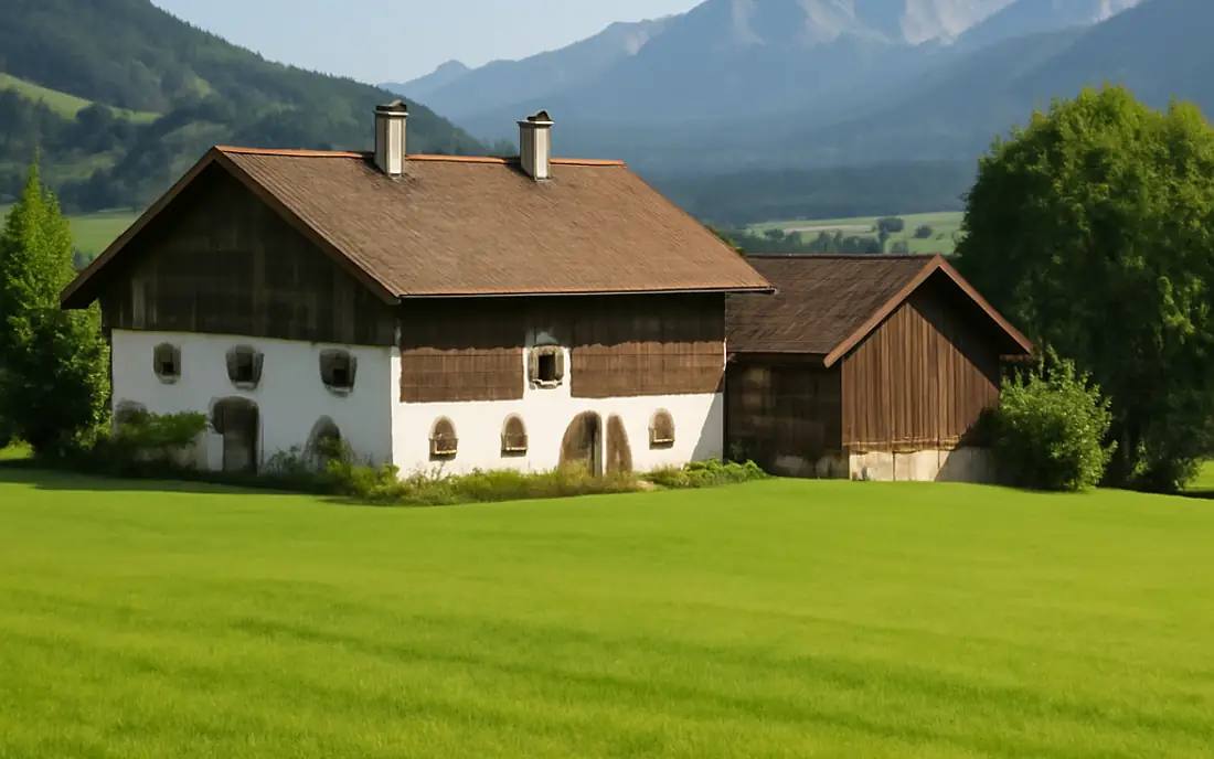 Ein ländlicher Bauernhof umgeben von grünen Wiesen und sanften Hügeln.