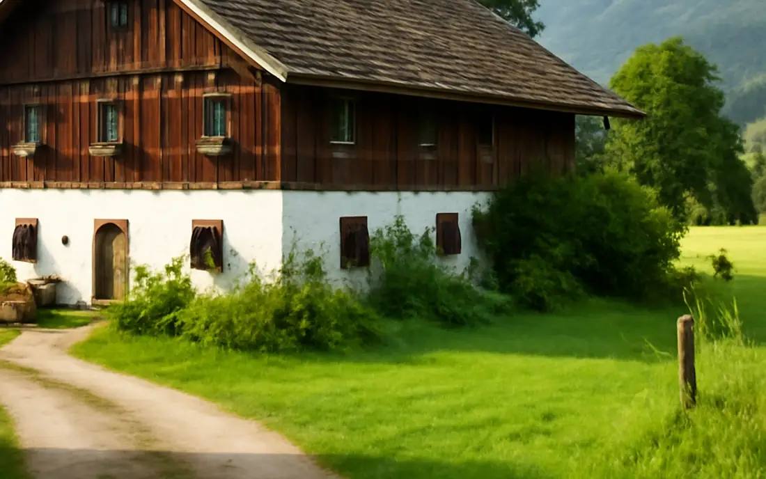 Ein ländliches Haus in der Natur, umgeben von Bäumen und sanften Hügeln.